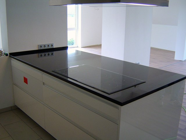 Kücheninsel mit Arbeitsplatte aus schwarzem Granit und Kochfeld